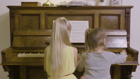 Rückansicht-Von-Zwei-Kleinen-Mädchen,-Die-Zu-Hause-Altes-Klavier-Spielen