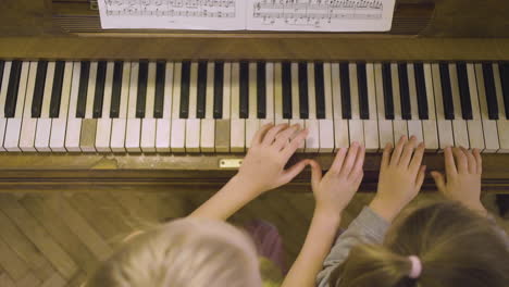 Top-View-Of-Two-Little-Girls-Playing-Old-Piano-At-Home