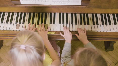 Draufsicht-Auf-Zwei-Kleine-Mädchen,-Die-Zu-Hause-Altes-Klavier-Spielen-1