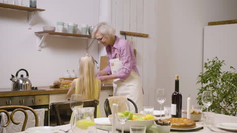 Kleines-Mädchen-Hilft-Ihrer-Großmutter,-Den-Tisch-Zum-Abendessen-Zu-Decken-Und-Teller-Zu-Bringen