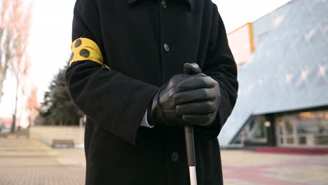 Close-Up-Of-An-Unrecognizable-Blind-Man-In-Coat-And-Gloves-Holding-Walking-Stick-While-Standing-In-The-Street-On-A-Winter-Day