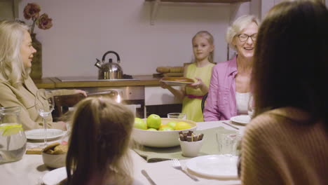 Little-Girl-Bringing-Pie-To-The-Table-During-A-Dinner-With-Her-Happy-Family-1