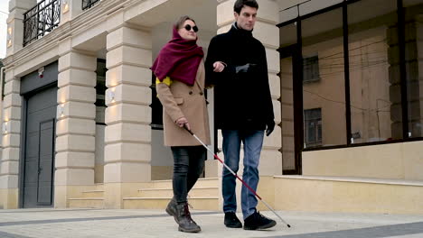 Bottom-View-Of-A-Man-And-A-Blind-Woman-Walking-In-The-Street
