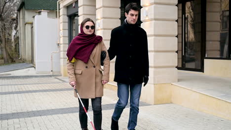 Front-View-Of-A-Man-And-A-Blind-Woman-Walking-In-The-Street-1
