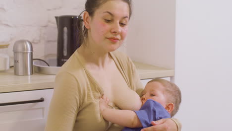 Young-Mother-Breastfeeding-Her-Baby-Boy-At-Home