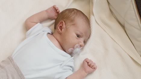 Adorable-Newborn-Baby-Lying-On-Bed-With-Dummy-In-His-Mouth-1