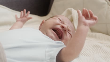 Close-Up-Of-A-Cute-Newborn-Baby-Lying-On-Bed-And-Crying-1