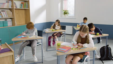 Multiethnic-Group-Of-Students-Sitting-At-Desks-In-English-Classroom-1