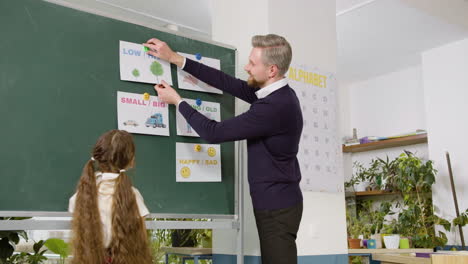 Teacher-And-Student-In-Front-Of-Blackboard-In-English-Classroom-1