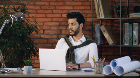 Young-Arabian-Architect-Working-On-New-Project-With-Laptop-Sitting-At-Desk-In-His-Office