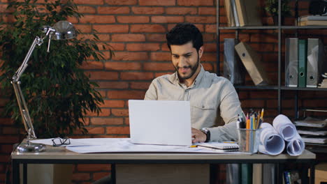 Young-Arabian-Architect-Finishing-His-Project-On-The-Laptop-And-Being-Cheerful-In-His-Office