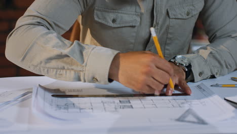 Close-Up-View-Of-Arabian-Artchitect-Hands-Drawing-A-Building-Plan-With-A-Pencil-And-Rule-On-Desk-While-Working-On-The-New-Project