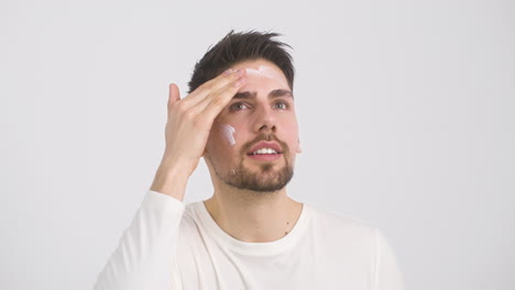 Attractive-Man-Applying-Moisturizer-To-His-Forehead