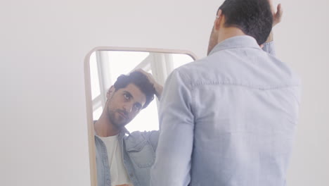 Good-Looking-Man-Touching-His-Hair-In-Front-Of-The-Mirror