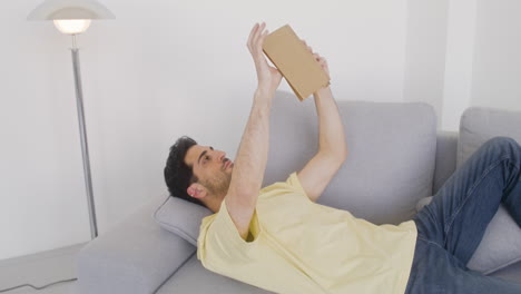 Attractive-Man-Reading-On-A-Sofa