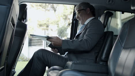 Bearded-Businessman-With-Laptop-And-Notebook-Getting-Into-Car