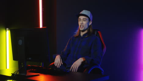 Close-Up-View-Of-Young-Man-Wearing-Cap-And-Playing-A-Game-On-The-Computer-And-Annoyed-By-Losing