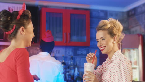 Two-Women-Talking-And-Smiling-In-An-American-Diner