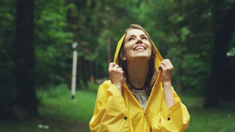 Close-Up-Of-Abeautiful-Woman-In-A-Yellow-Raincoat-Standing-In-The-Middle-Of-The-Forest