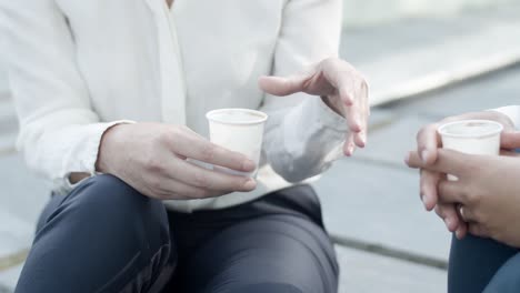 Bürokolleginnen-Sitzen-Und-Trinken-Kaffee-Zum-Mitnehmen,-Reden-Und-Gestikulieren