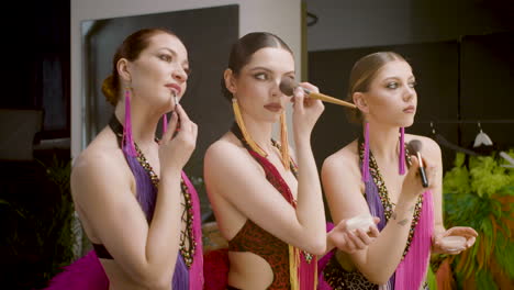 Three-Showgirls-Applying-Makeup-In-The-Backstage