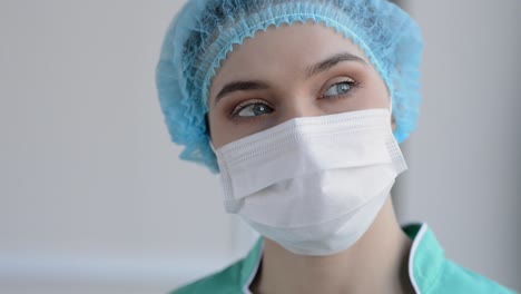 Portrait-Of-Beautiful-Nurse-With-Medical-Mask-Looking-At-Camera-And-Smiling