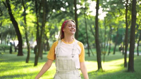 Pretty-Cheerful-Girl-Enjoying-Freedom-And-Walking-Towards-The-Camera-In-A-Green-Park