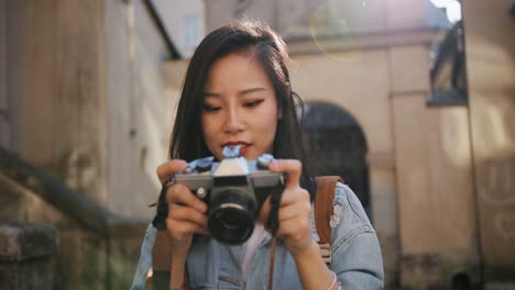 Close-Up-Of-The-Beautiful-Young-Woman-Taking-A-Picture-With-A-Photocamera-And-Then-Smiling-In-The-Historical-Town-In-Sunlight