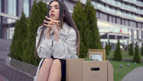 Close-Up-Of-A-Beautiful-Woman-Sitting-In-Front-Of-An-Office-Building
