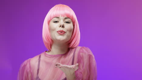 Portrait-Of-Stylish-Woman-Wearing-A-Pink-Wig-Smiling-To-Camera-And-Blowing-Kisses