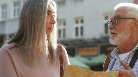 Close-Up-Of-Senior-Couple-Standing-Outdoors-With-A-Map-And-Deciding-Which-Way-To-Take