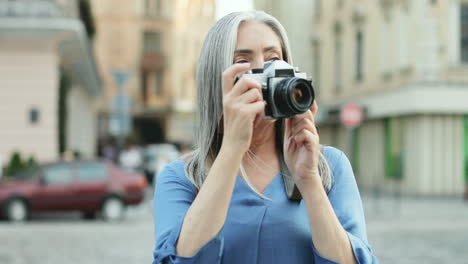 Close-Up-Of-Senior-Woman-Tourist-Taking-Photos-In-The-City-Center
