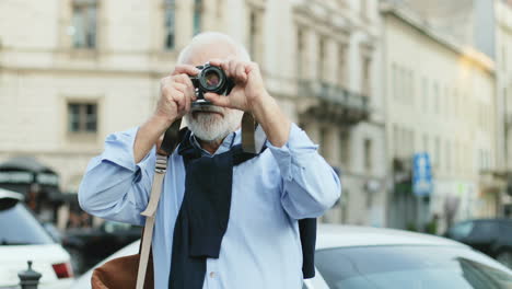 Porträt-Eines-älteren-Mannes-Mit-Langen-Haaren,-Der-Vor-Der-Kamera-Steht-Und-Fotos-Macht