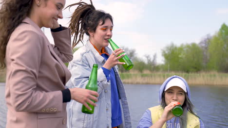 Cuatro-Mujeres-Brindando-Y-Bebiendo-Cerveza-Junto-Al-Río