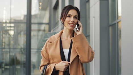 Front-View-Of-Businesswoman-Talking-On-Phone-While-Walking-The-Street