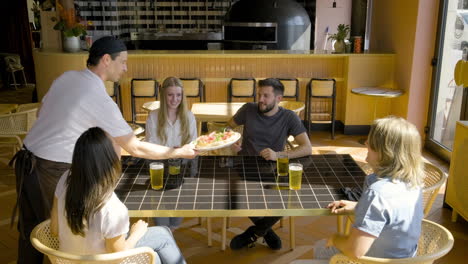 Top-View-Of-Group-Of-Friends-Sitting-At-A-Restaurant-Table-While-They-Talk-To-Each-Other