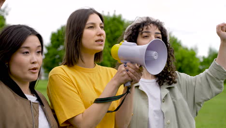 Three-Female-Friends-In-A-Protest-Using-A-Megaphone