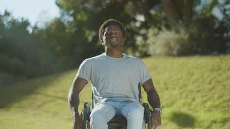 Young-Black-Man-Riding-His-Wheelchair-In-Green-Summer-Park