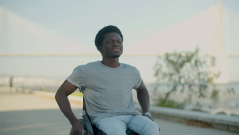 Junger-Schwarzer-Mann,-Der-Im-Rollstuhl-Entlang-Der-Küste-Fährt