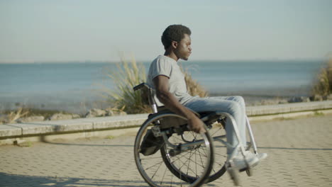 Young-Black-Man-In-Wheelchair-Having-Fun-At-Seafront