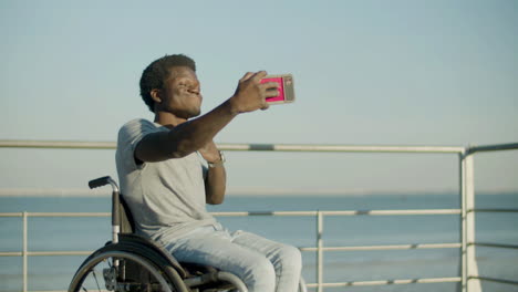 Junger-Mann-Im-Rollstuhl,-Der-Selfie-Vor-Meereshintergrund-Macht