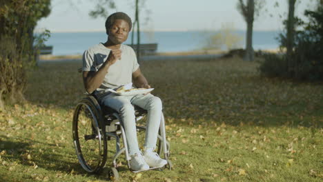 Young-Black-Man-In-Wheelchair-Having-Lunch-In-City-Park-1