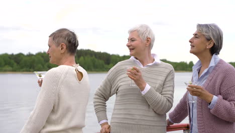 Drei-ältere-Frauen,-Die-In-Der-Nähe-Eines-Sees-Etwas-Trinken