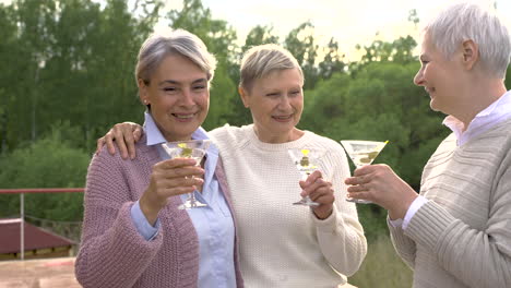 A-Group-Of-Three-Senior-Women-Hugging-And-Having-A-Drink