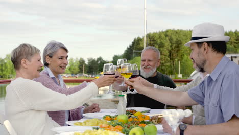 A-Group-Of-Senior-People-Are-Having-Dinner,-Toasting-And-Drinking