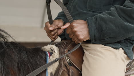 Close-Of-Of-A-Man's-Hand-Riding-A-Brown-Horse