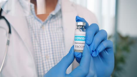 Close-Up-Shot-Of-Healthcare-Worker-Specialist-In-Protective-Uniform-Holding-In-Hands-In-Gloves-Ampoule-With-Coronavirus-Vaccine,-Covid-19-Vaccination-Concept,-Virus-Cure-Medicament,-Healthcare