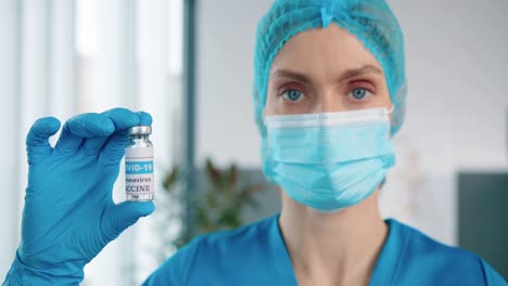 Close-Up-Of-Female-Healthcare-Specialist-Virologist-In-Protective-Uniform-And-Medical-Mask-Holding-In-Hand-In-Gloves-Ampoule-With-Coronavirus-Vaccine,-Covid-19-Vaccination-Concept-Virus-Cure