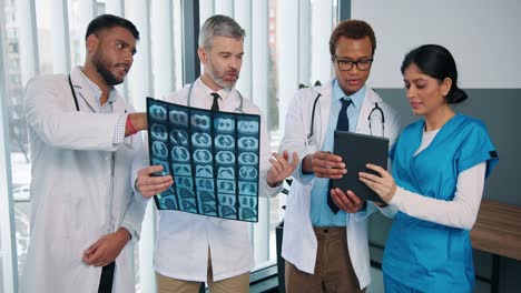 Portrait-Of-Multi-Ethnic-Different-Male-And-Female-Doctors-In-Clinic-Speaking-Together-Discussing-X-Ray-Scan-Disease-Treatment,-Typing-On-Tablet-Device,-Professional-Nurses-And-Physicians-In-Hospital