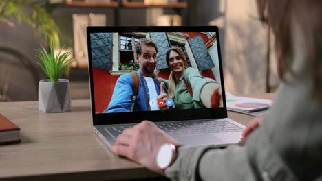 Woman-Sitting-At-Desk-And-Having-Video-Call-With-Couple-Of-Joyful-Friends-On-Computer